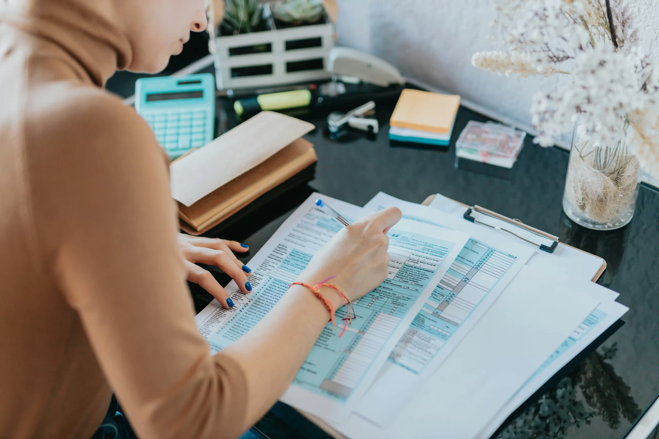 Self-employed tradesperson organising receipts, invoices and tax records before the UK tax deadline